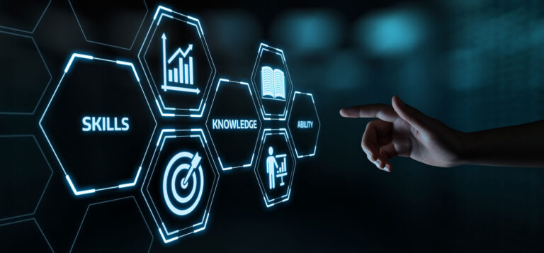 Finger pointing at a screen with various images including the word Skills, Knowledge, Ability